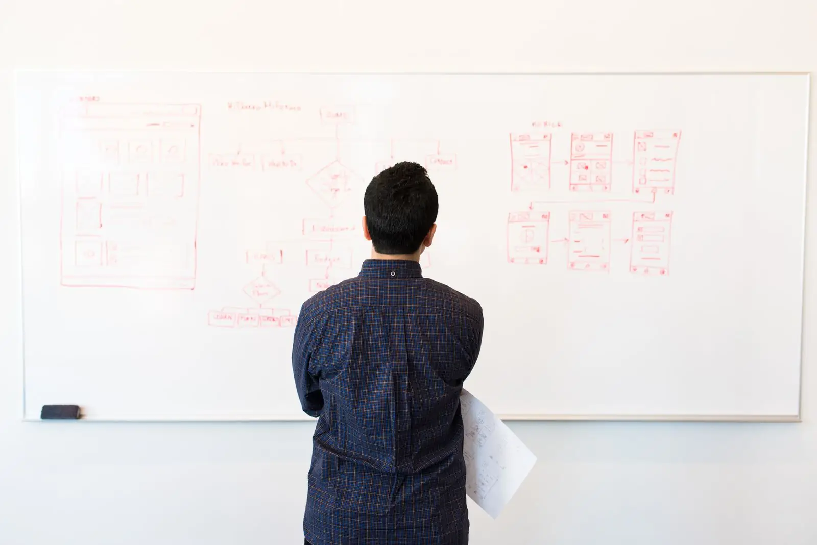 Engineer reviewing a system design sketched on a whiteboard
