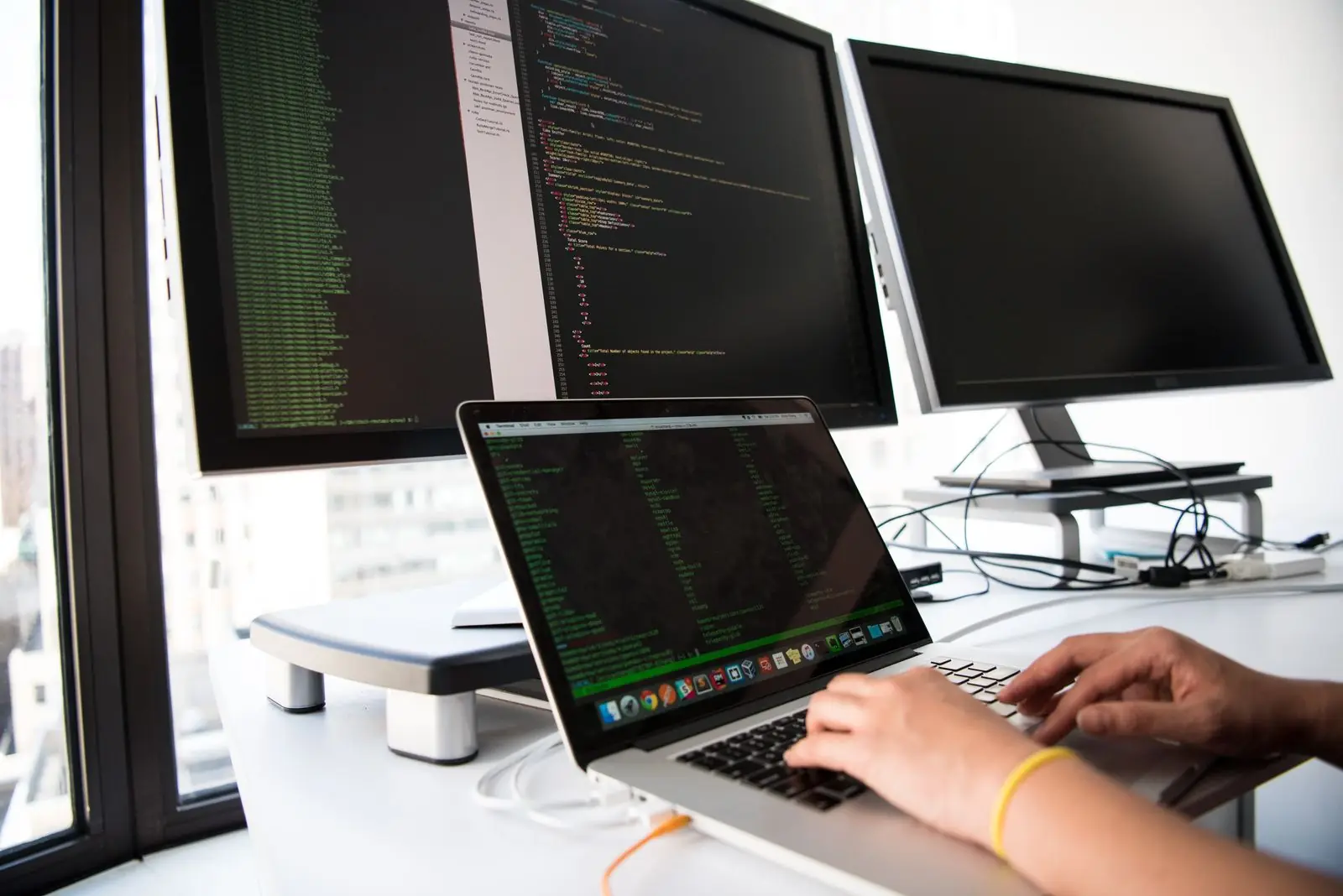 Developer workstation with code on several monitors