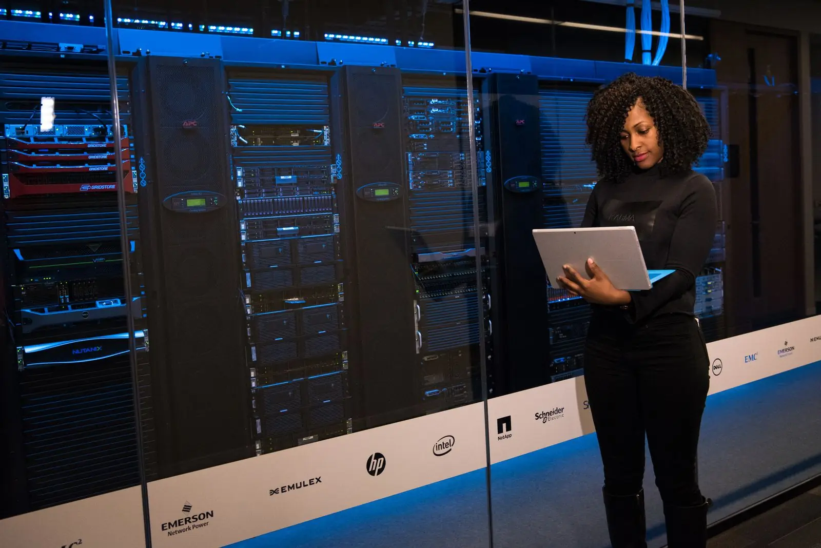 Engineer with a laptop beside server racks in a data center